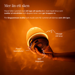 Havie med inbyggt vitt brus och 360-graders högtalare sprider ett varmt orange sken.